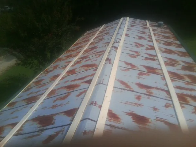 Rusted metal roof panels with new wood purlins before replacement — Storm Damage Roof Repair in Hyde Park by Roofing Brothers